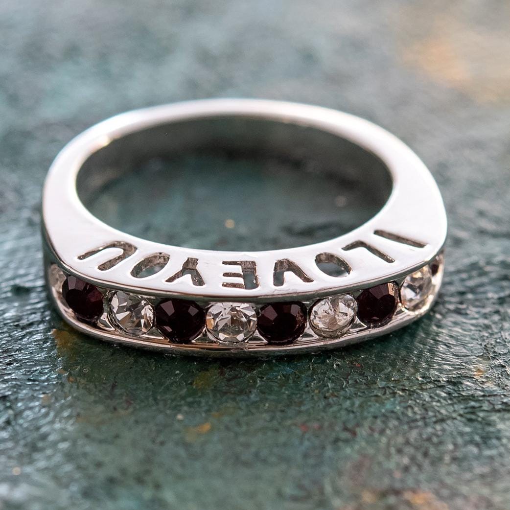 Silver tone band ring with engraved I Love You text and alternating garnet and clear Austrian crystals in channel setting