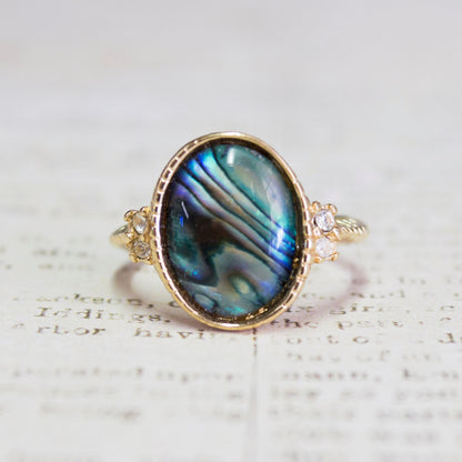 Vintage gold electroplated ring with oval blue-green abalone shell and clear Swarovski crystal accents on a twisted rope band